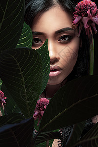 位美丽的亚洲女人带着植物叶子的特写肖像图片