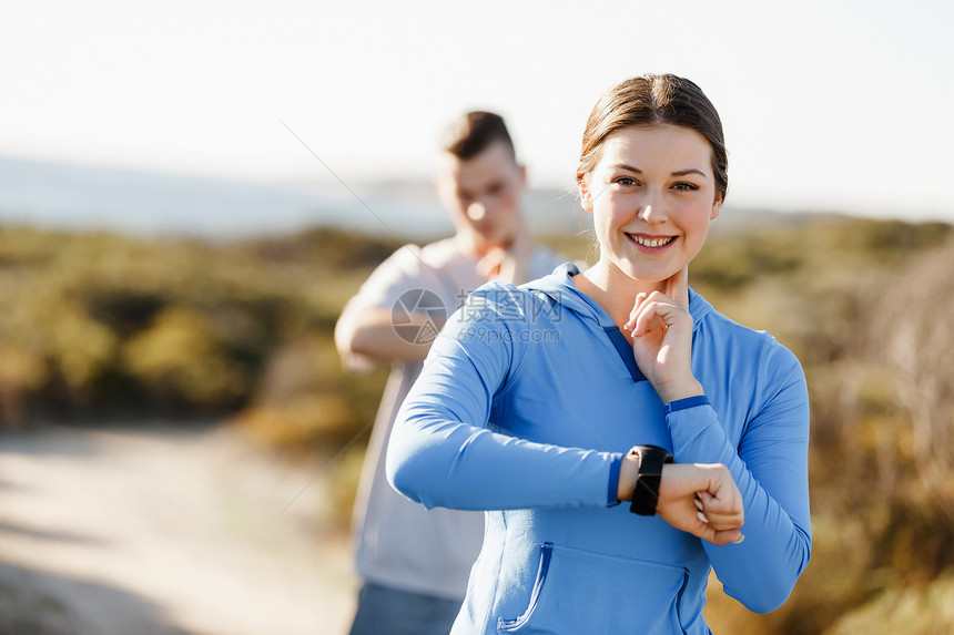 跑步的女人带着心率监视器海滩上跑步轻的跑步女子,心率监测器海滩上跑步图片