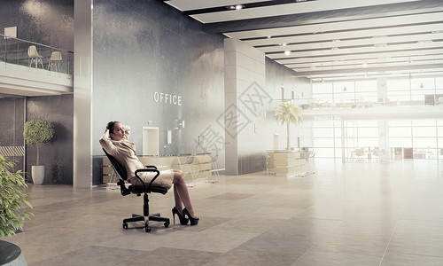 女商人办公室休息轻轻松的女商人办公室的椅子上放松地坐着背景图片