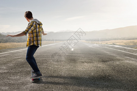 男孩骑滑板活跃的家伙骑滑板沥青路上背景图片