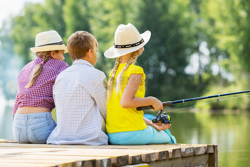 夏季休闲三个孩子坐岸边钓鱼的后视镜图片
