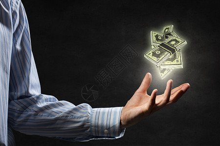 把你的钱投资正确商人黑暗的背景下手掌握着抽出来的钞票设计图片