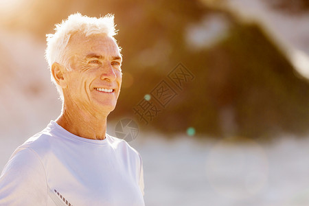 穿着运动服站海滩上的男人站海滩上的男人穿着运动服,看来既健康又快乐图片