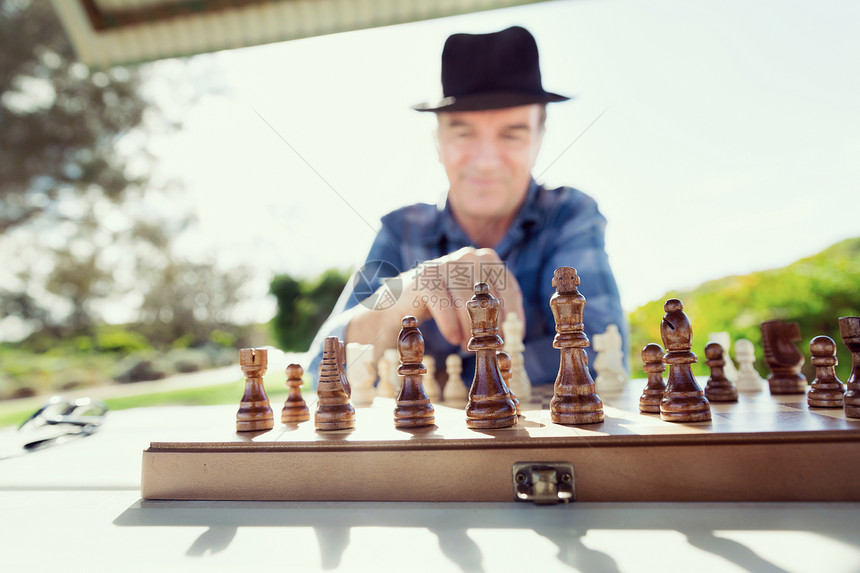 老人坐户外下棋思考国际象棋策略图片