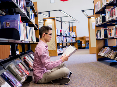 快乐的男学生图书馆书快乐的亚洲男学生图书馆书图片