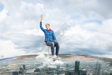 成功的轻的女孩坐高高的天空中的椅子上图片