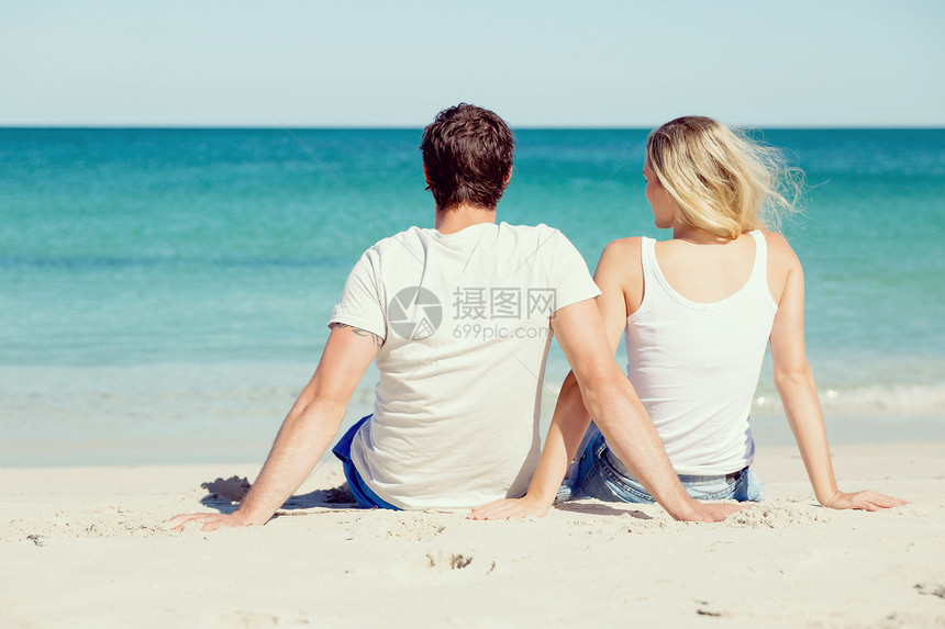 浪漫的轻夫妇坐海滩上浪漫的轻夫妇坐海滩上看着大海图片
