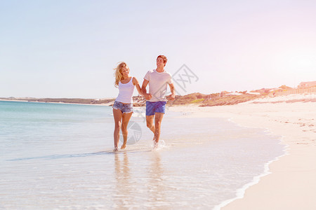 浪漫的轻夫妇海滩上浪漫的轻夫妇海滩上沿着海岸散步高清图片