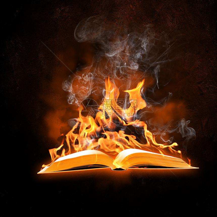 燃烧的书黑色背景下打开的燃烧书的图像图片