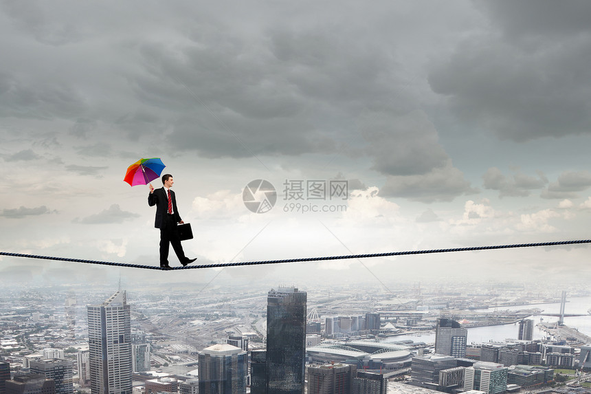 准备好冒险了商人用伞平衡绳子上高天空上图片