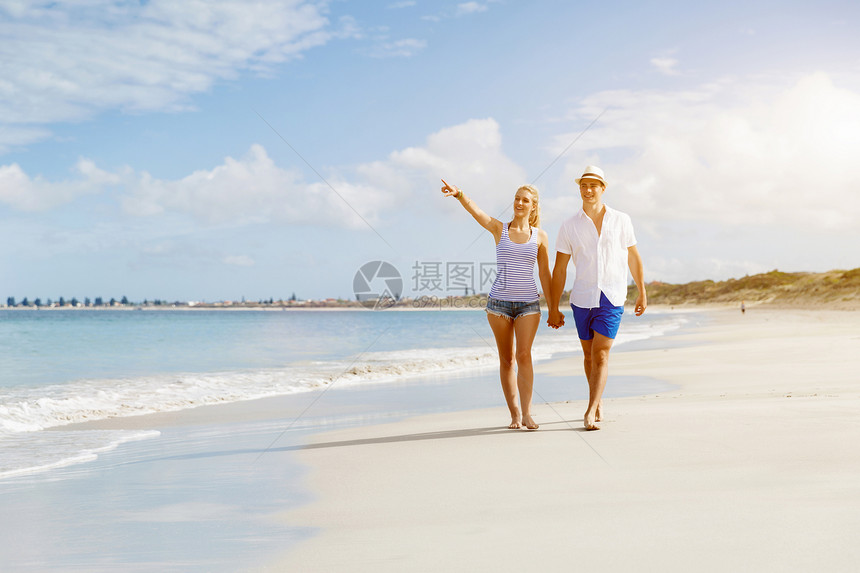 浪漫的轻夫妇海滩上浪漫的轻夫妇海滩上沿着海岸散步图片