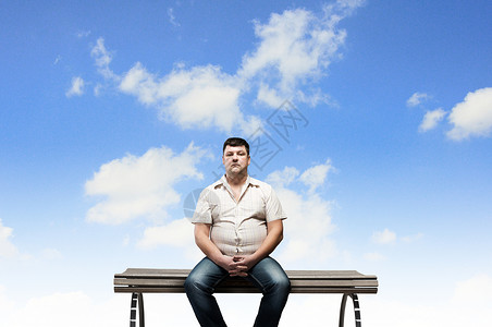 胖子坐长凳上看着远方胖子图片