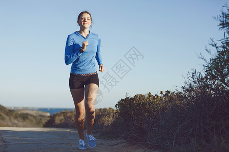运动跑步者海滩上慢跑锻炼适合女健身模型沿海洋慢跑高清图片