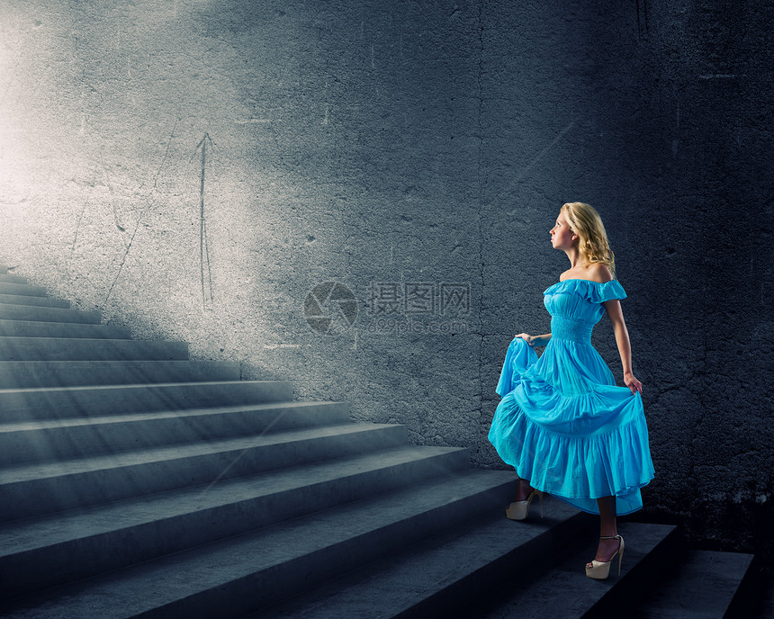 穿蓝色裙子的女孩穿着蓝色连衣裙的轻金发女人走上楼梯图片