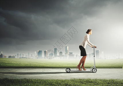 女商人骑着滑板车吸引力的女商人骑滑板车的形象图片