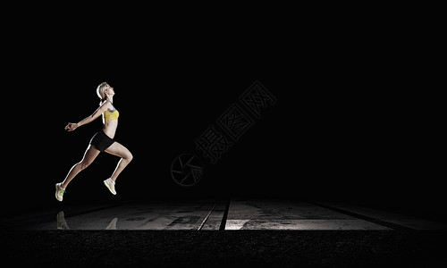 夜跑步全速前进轻的女运动员黑暗的背景下跑得很快背景