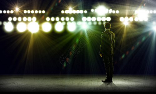 灯光舞台地灯演讲者舞台上站舞台灯光下的商人的后视镜背景