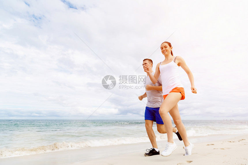 跑步者轻夫妇海滩上跑步跑步者轻夫妇海滩上跑步图片