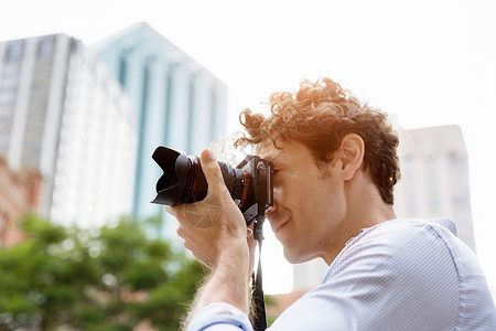 男摄影师拍照专业摄影师城市拍照背景图片