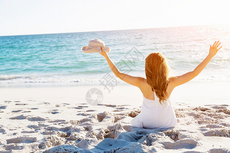 比基尼女孩素材轻的女人坐海滩上坐沙滩上的轻漂亮女人的肖像背景