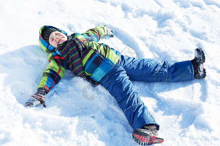 冬天的乐趣快乐的孩子躺冬天公园的雪地上图片