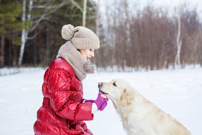 她最好的朋友冬天公园里带着拉布拉多狗散步的女孩图片