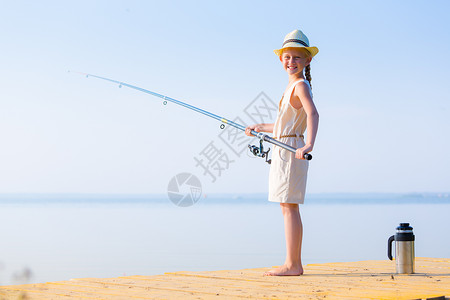 钓鱼女孩穿着连衣裙帽子的女孩带着钓鱼竿码头钓鱼背景
