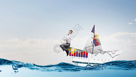 商人用纸的船成功的商人金融海洋的纸船上航行图片