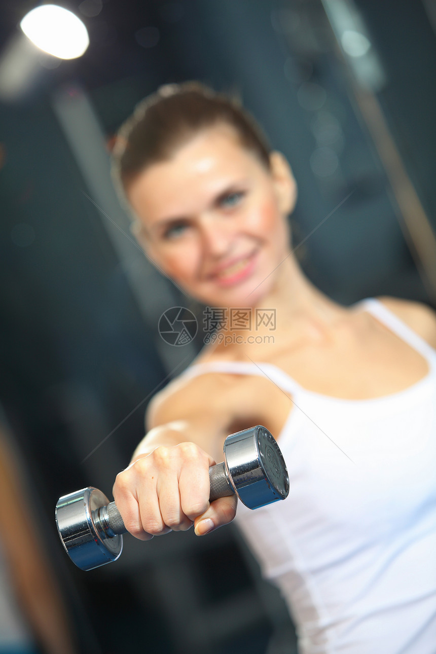 运动女孩健身女孩健身房锻炼哑铃的形象图片