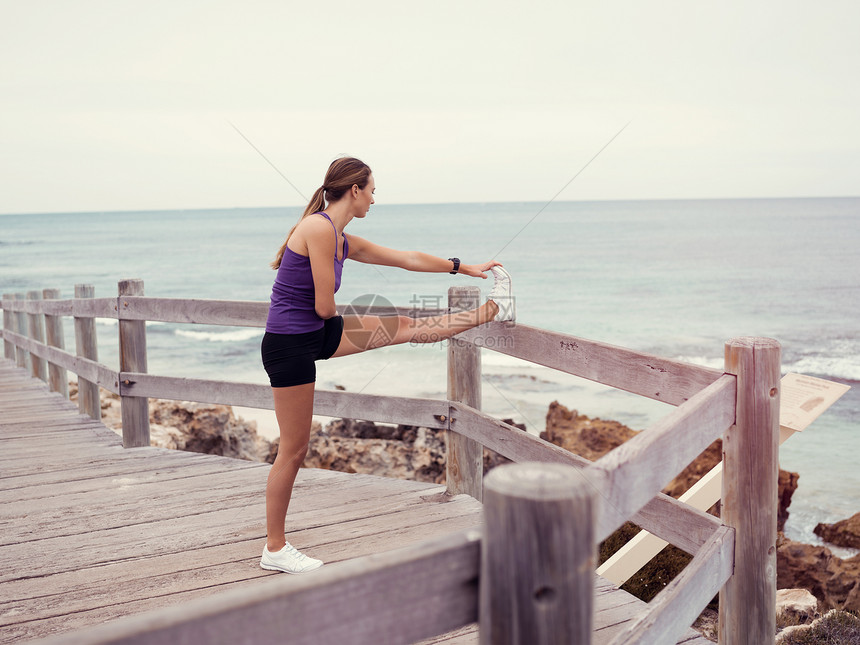 运动的轻女人海边伸展图片
