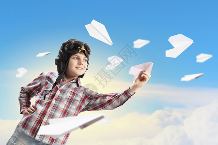 飞行员头盔里玩纸飞机的小男孩的形象图片