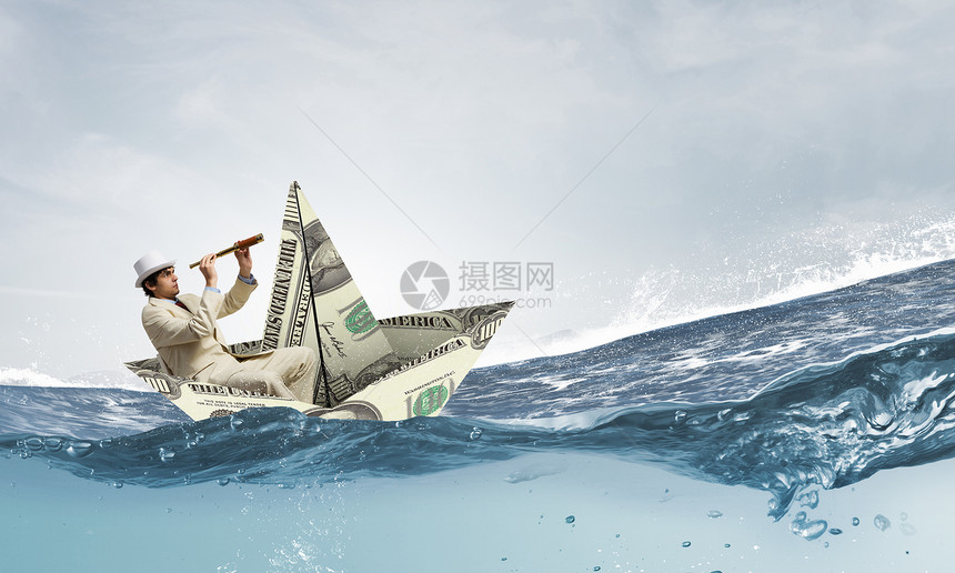 商人用美元钞票的船成功的商人金融海洋中乘船航行图片
