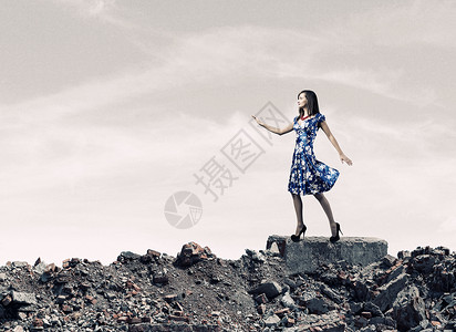 穿蓝色裙子的女人穿着蓝色衣服的轻女人走城市废墟中图片