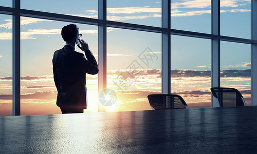 他工作日落夕阳下,优雅的商人办公室里背景图片