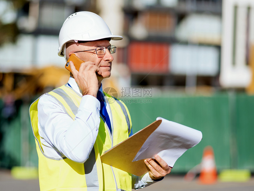 建筑工地的工程师建设者工程师建筑工人施工场景穿着安全背心记事本图片