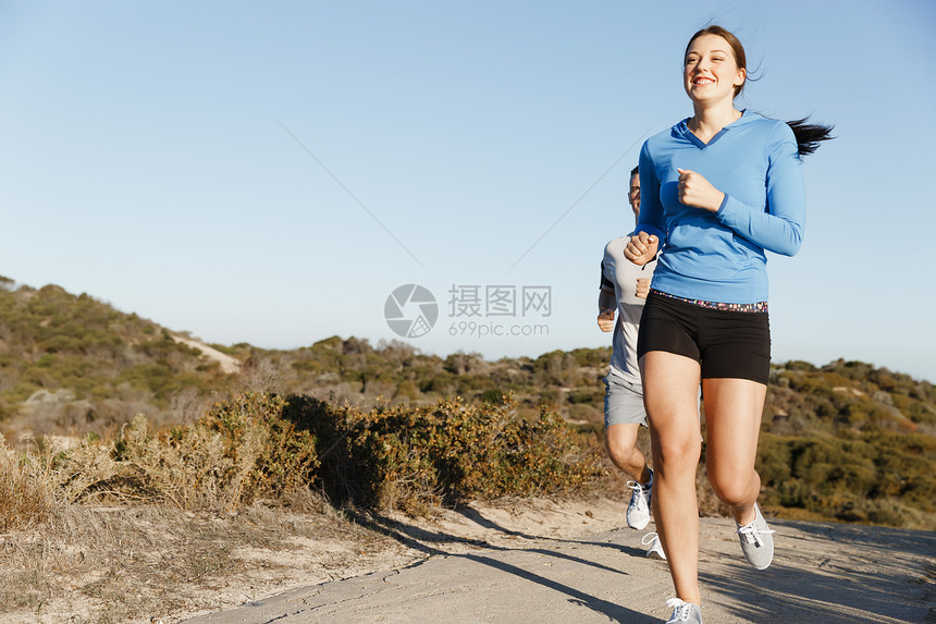 运动跑步者海滩上慢跑,她的搭档锻炼适合女健身模式慢跑沿海洋与她的伴侣图片