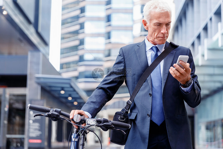 成功的商人骑自行车用手机成功的商人城市自行车上着手机图片