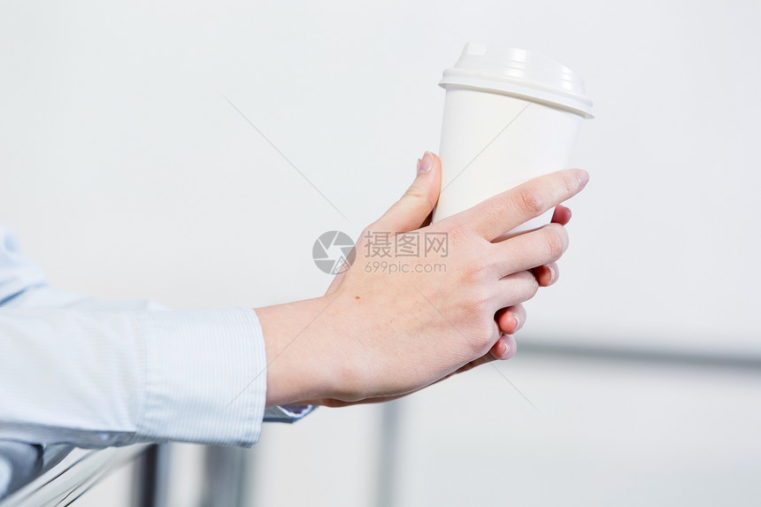用塑料杯把站阳台上的人的手合来图片