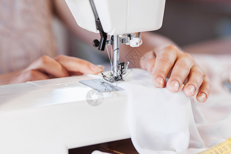 裁缝工作室密切妇女裁缝的手与缝纫机工作背景图片