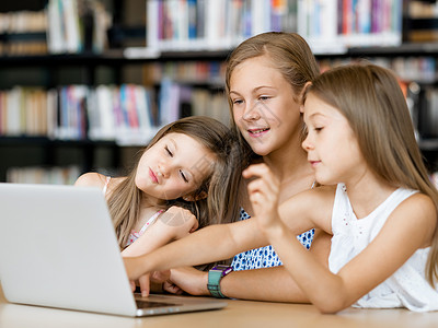 图书馆里着笔记本电脑的小女孩图书馆的技术背景图片