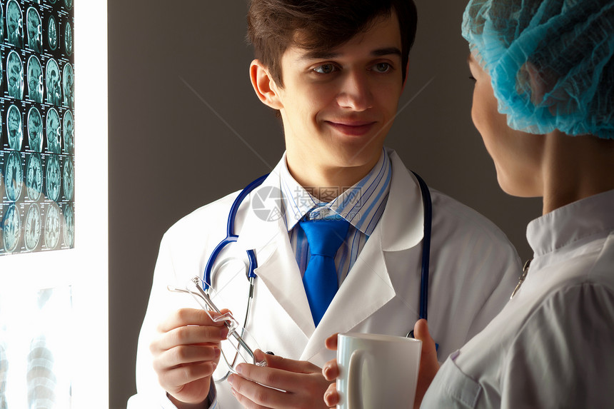两名医生检查X光结果两名轻的两名医生讨论结果的图像图片