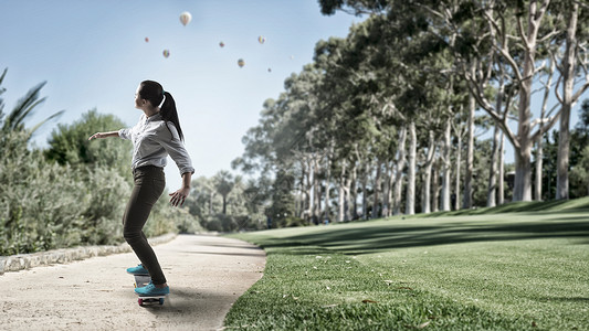 女孩骑滑板活跃的女孩公园的路上骑滑板图片