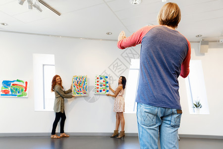 廉洁文化挂画画廊里的轻艺术家墙上挂画画廊里的轻艺术家们把画挂墙上背景