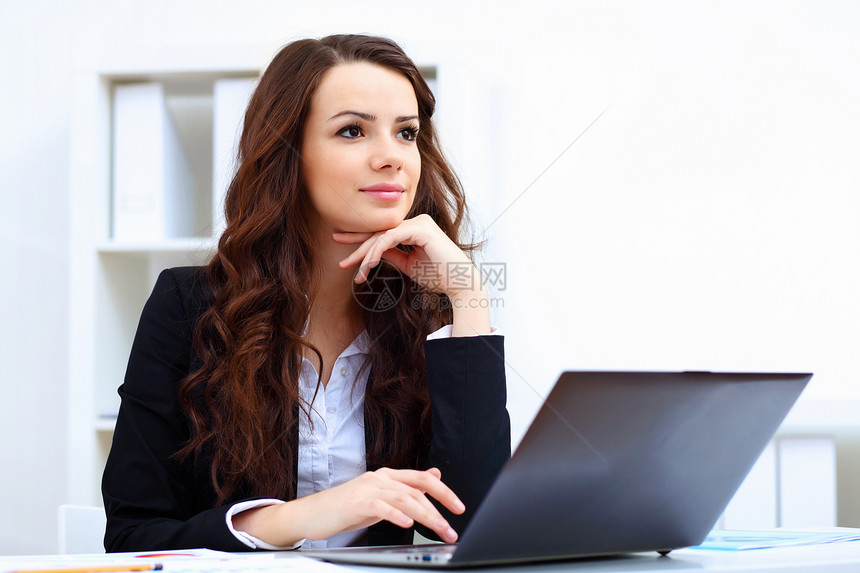 正在使用电脑微笑着思考的女性图片