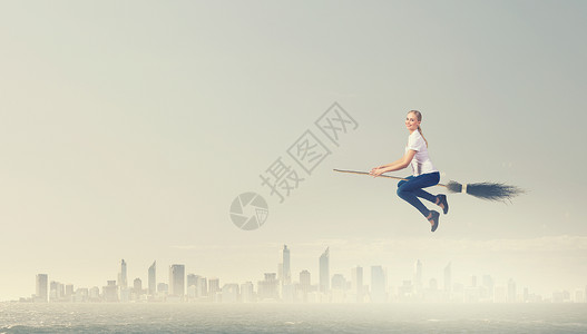 飞行扫帚女孩乘扫帚飞快乐的轻女人扫帚上飞翔背景