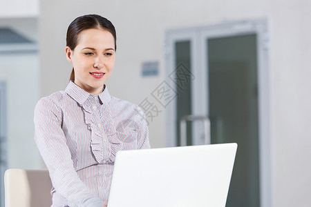 用笔记本电脑的女人轻漂亮的女孩随意坐着用笔记本电脑图片