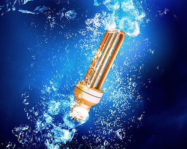 灯泡水下能量与灯泡清澈的蓝色水背景图片