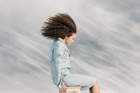 商业上的挑战轻的女商人,挥舞着头发坐建筑物的顶部图片