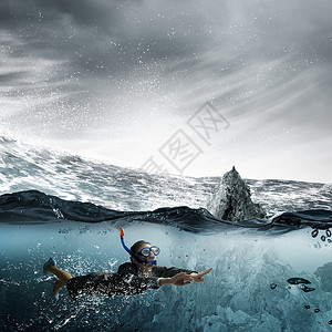 水下的女人穿着西装潜水具的轻女商人水下游泳背景图片