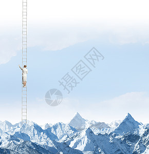 达顶峰女商人站高高的山上的梯子上图片